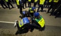 Police in hi-viz jackets and a medic as a person appears to be detained