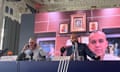 The IBA president, Umar Kremlev, is seen on a big screen at a press conference in Paris, with the IBA chief Chris Roberts and coaching official Gabriele Martelli