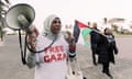 Protester wearing a FREE GAZA T-shirt holds loudspeaker