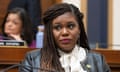 Black woman wearing black jacket and white shirt looks to her right