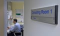 Doctor working in a consulting room with a sign on the door