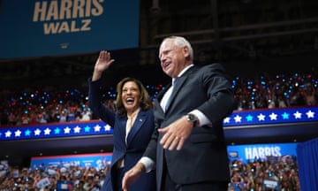 Man and woman smile on stage at convention center