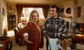 film still of a man and a woman standing in a living room
