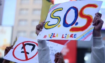 People hold anti-Maduro signs in the air.