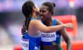Sharon Firisua (right) of Solomon Islands, gets a hug from Temalini Manatoa, of Tuvalu, after a heat in the women's 100m’s.